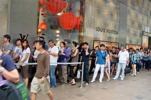 Una fila di clienti cinesi fuori da un negozio Lv
